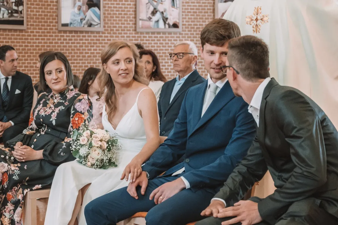 Poročna fotografija mladoporočencev; ujet pristen trenutek z naravno svetlobo in umirjeno kompozicijo v dokumentarnem slogu.